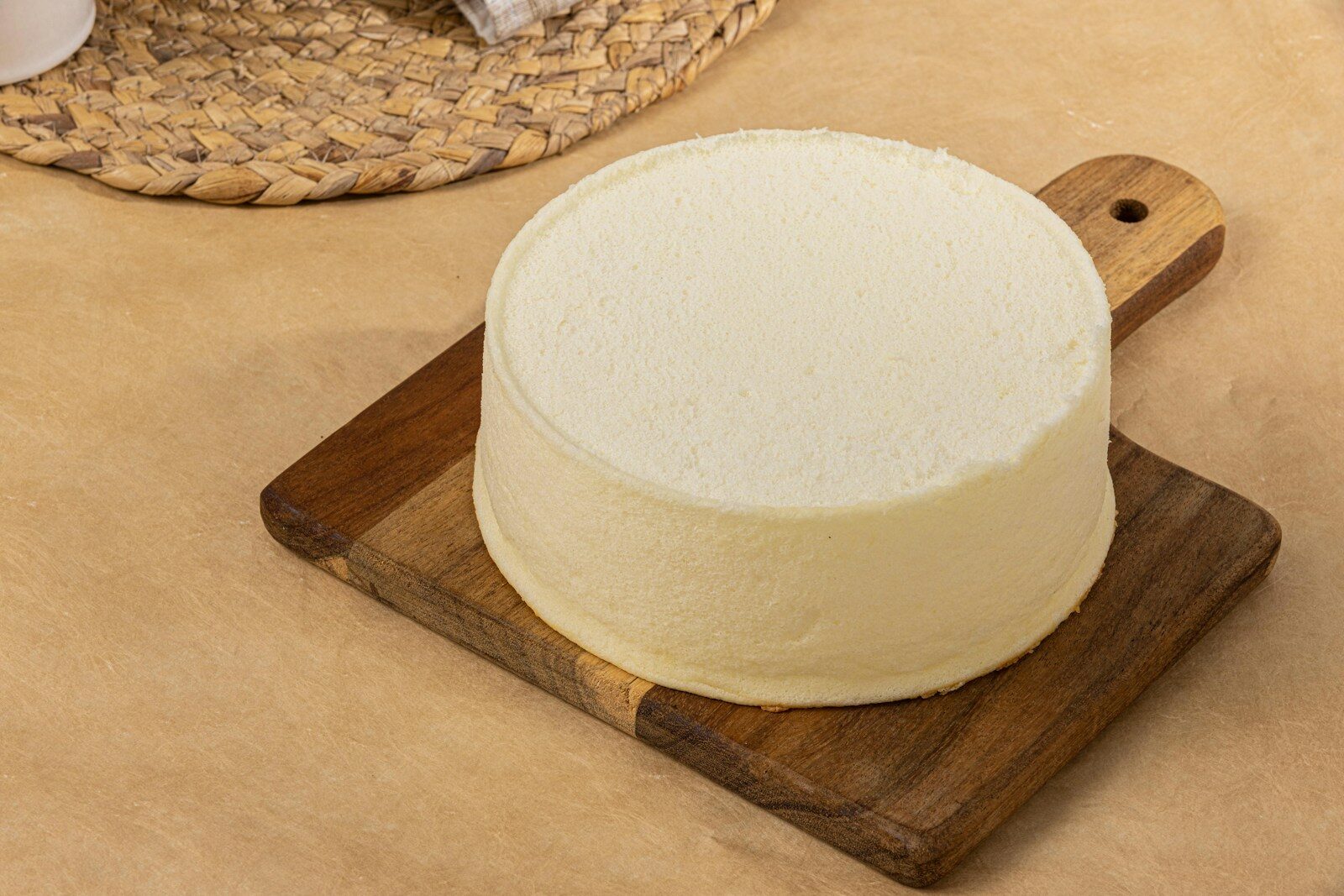 A round cake sitting on top of a wooden cutting board